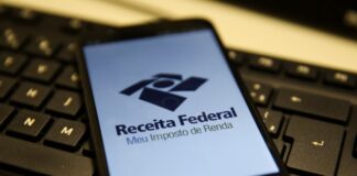 Receita Federal antecipa liberação do programa do Imposto de Renda 2026 Celular com logo da Receita Federal